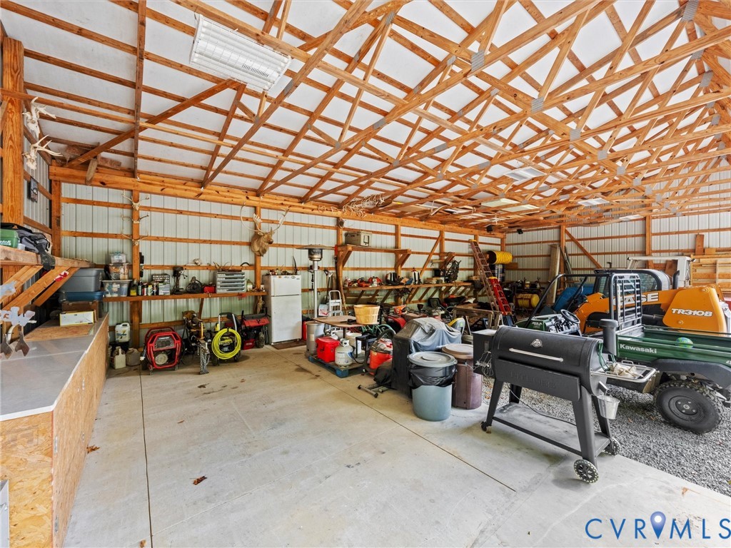 The spacious equipment barn offers ample room for tractors, farm machinery, tools, and workshop projects. Featuring exposed wood trusses, electricity, and a versatile open layout, this functional space is ideal for farm maintenance, equipment storage, and hobbies!