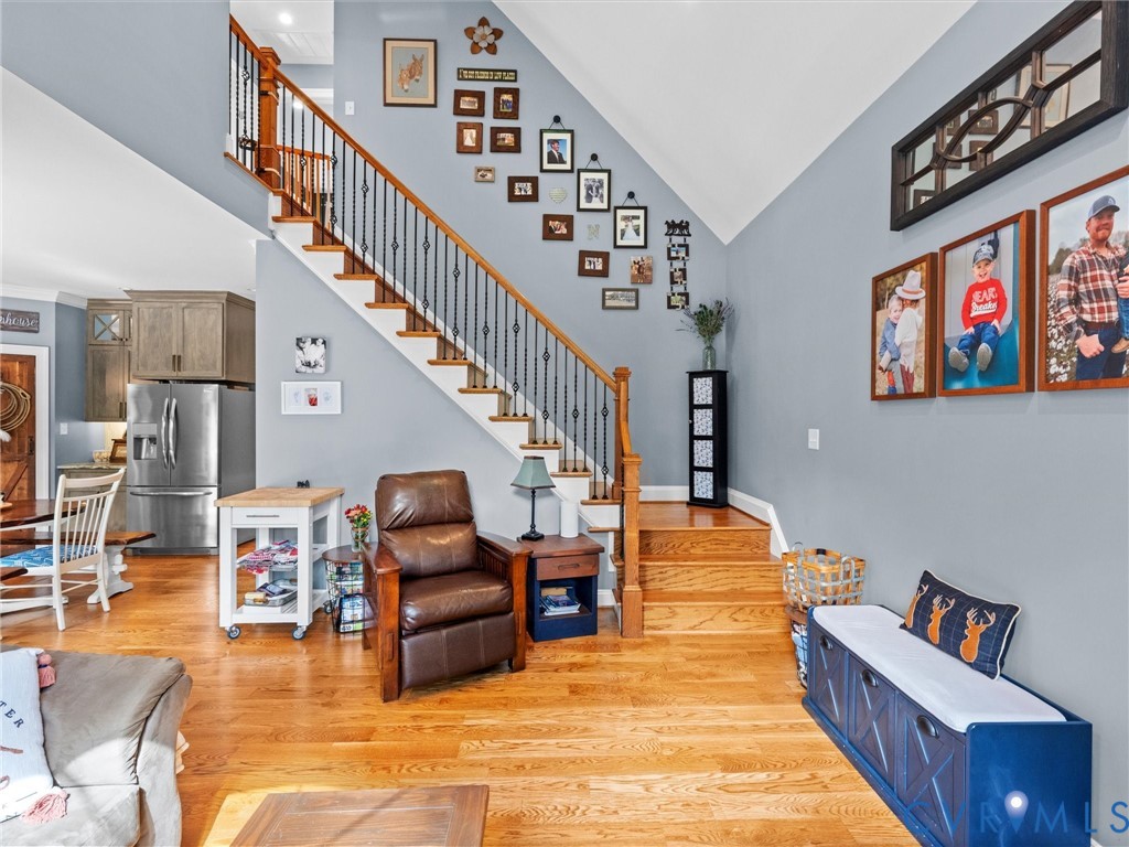 The beautiful open staircase features hardwood treads and elegant wrought iron balusters, adding architectural charm to the two-story family room. An open layout creates a seamless connection between the main living spaces and upper level!