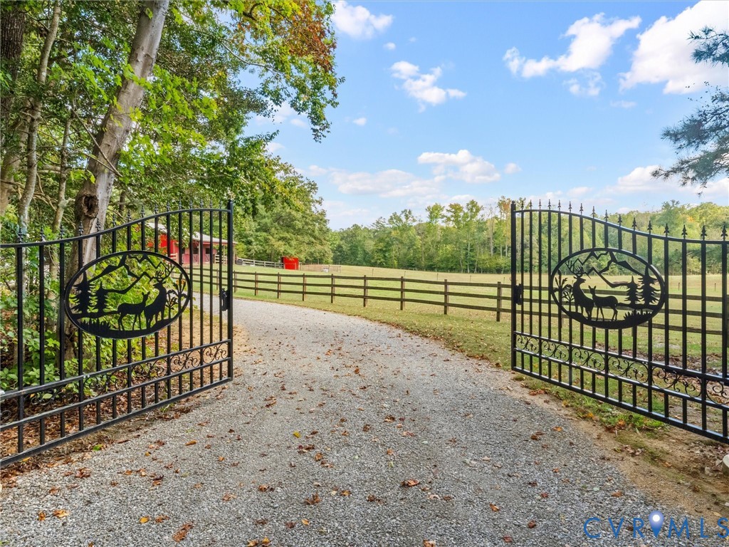A beautiful entrance welcomes you to The Little Red Homestead! Elegant wrought iron gates with an automatic gate opener lead to a picturesque gravel driveway, framed by mature trees and scenic fenced pastures. A stunning first impression of this peaceful country retreat!