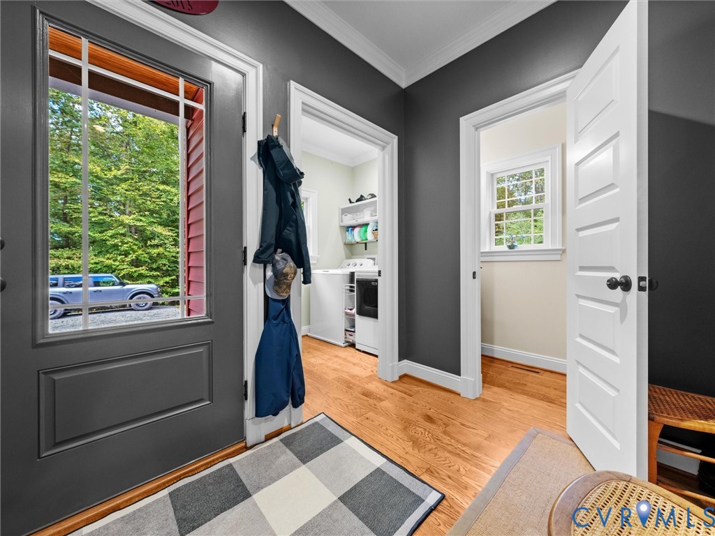 The welcoming side-entry foyer features beautiful hardwood floors, a convenient half bath, and easy access to the laundry room. A thoughtfully designed space that combines everyday functionality with farmhouse charm!