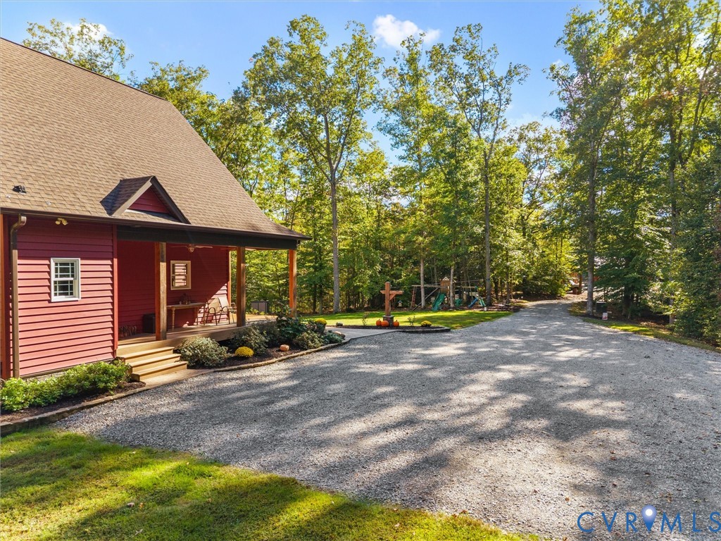 Convenient side entrance leads directly into the foyer, with a charming covered entry, attractive landscaping, and an expansive gravel parking area offering plenty of space for vehicles and guests.