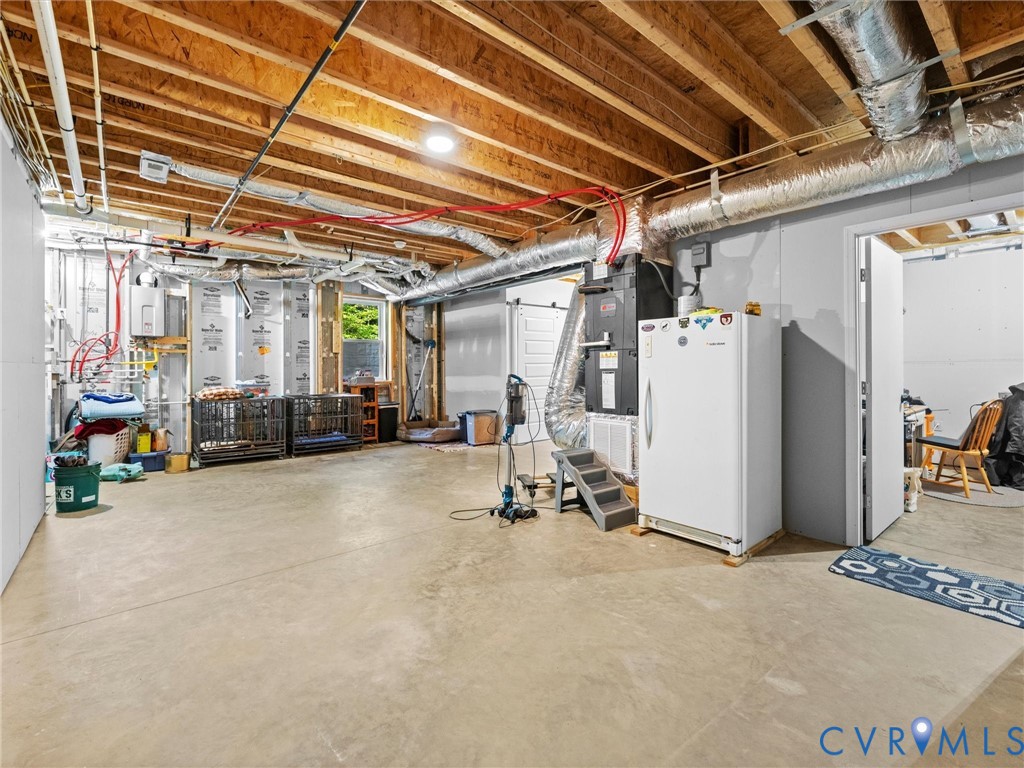 Another view of the spacious, partially finished walk-out basement, complete with heating and cooling, a tankless hot water heater, and ample room for storage, hobbies, or future finishing possibilities!