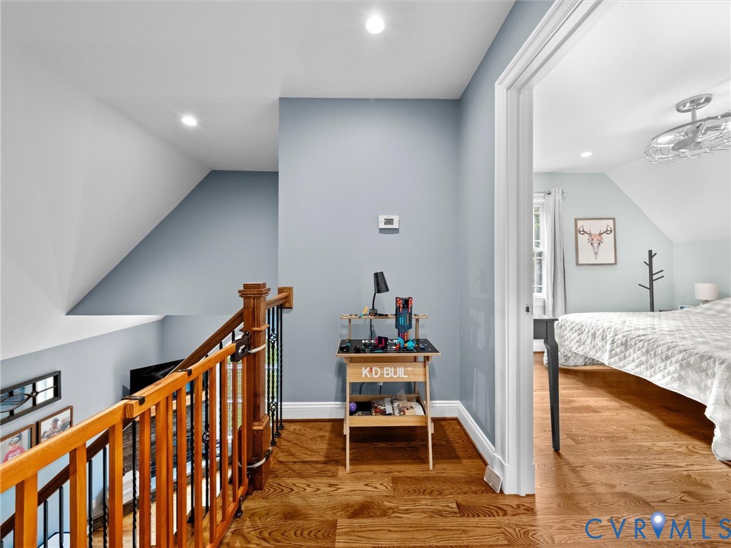 The spacious upper-level landing overlooks the two-story family room and features beautiful hardwood floors, wrought iron balusters, and access to the upstairs bedrooms. A bright, open design that adds to the home's inviting character!