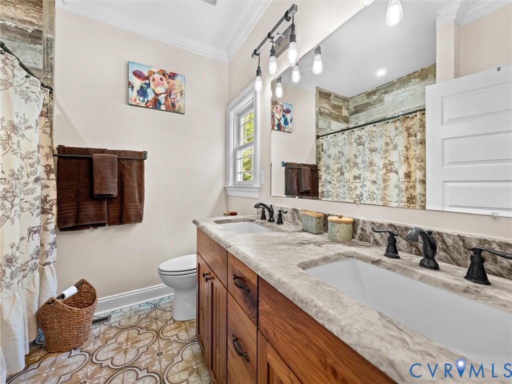 The primary en-suite bath features beautiful tile flooring, leathered granite countertops, a dual-sink vanity, and a tub/shower combination with a tile surround. A thoughtfully designed space combining style and everyday functionality!