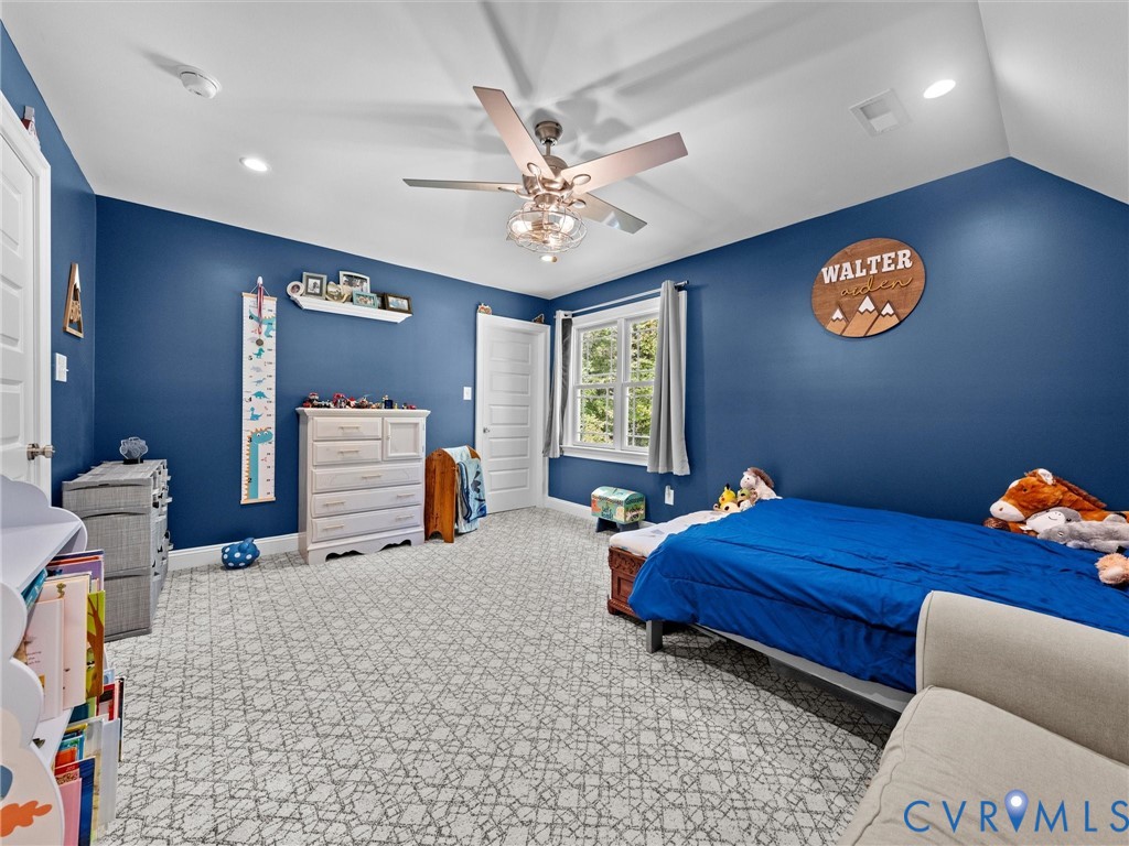 Another view of spacious second-level Bedroom 3 showcases the generous room size, two walk-in closets, plush carpeting, lighted ceiling fan, and two windows providing natural light. Plenty of space for comfortable living!