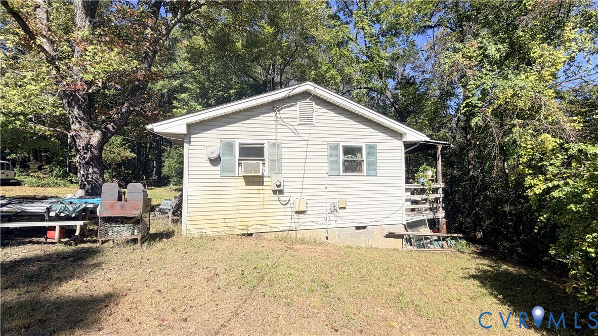 Exterior featuring light-toned horizontal siding, gable roofline, decorative window shutters, and a partially covered side porch