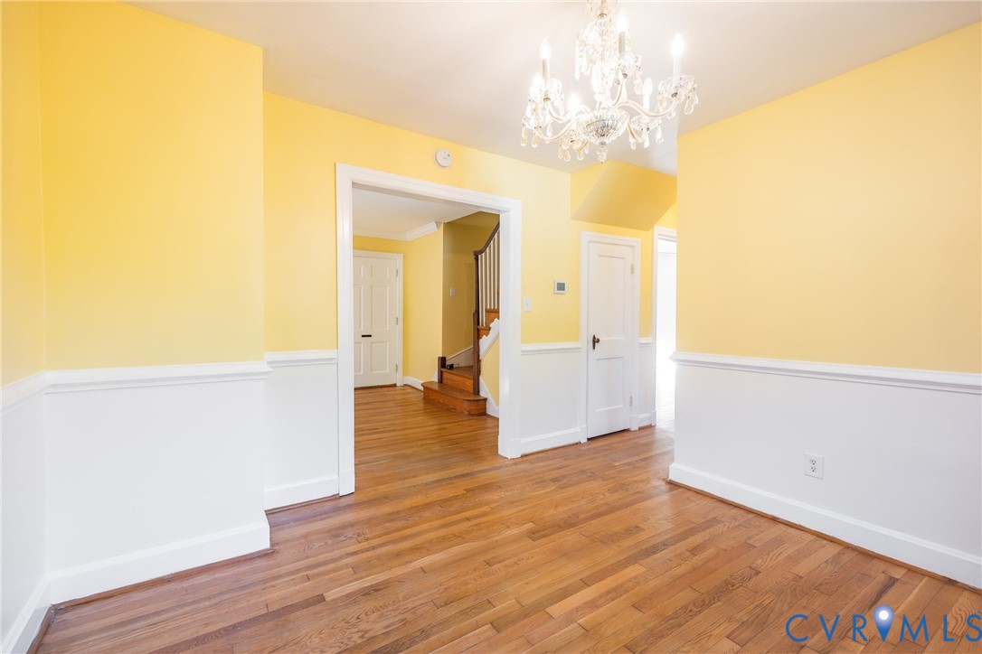 Interior space featuring wood-finish flooring, multi-panel doors, and a crystal-style chandelier
