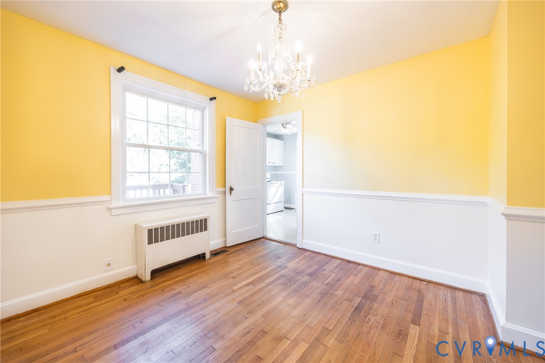 Room featuring wood-finish flooring, and a multi-light crystal chandelier