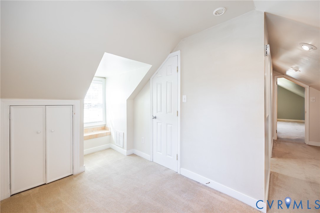 Vaulted ceilings, built-in under-eave storage cabinetry, recessed lighting, and a multi-panel interior door