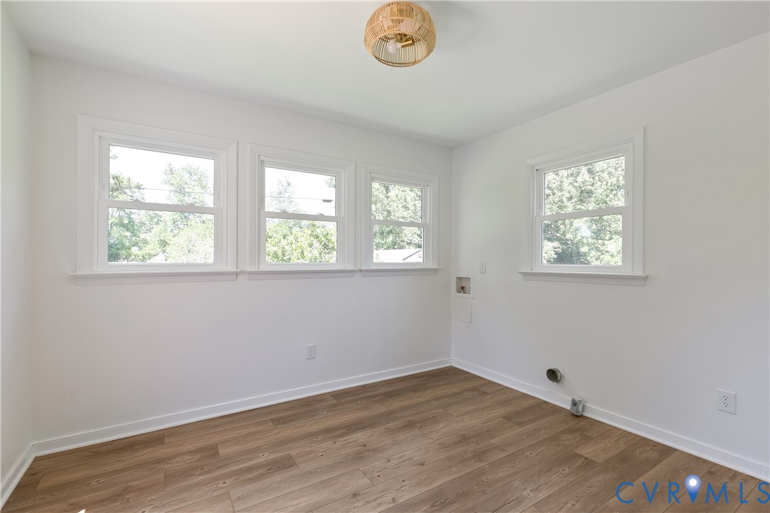 Room featuring wood-finish flooring, white walls, and white trim