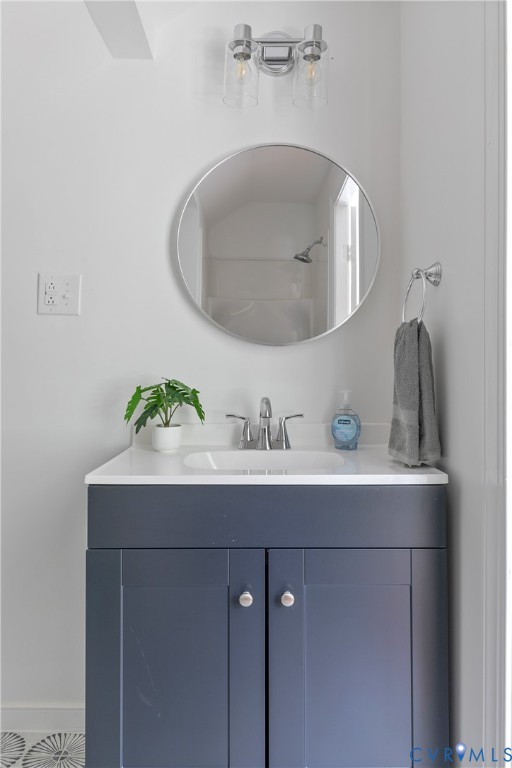 Modern bathroom vanity featuring a dark navy cabinetry base with dual doors, white quartz countertop, and integrated rectangular sink