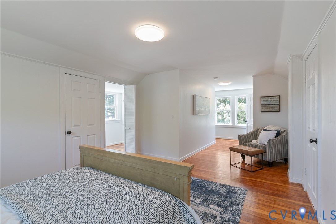 Hardwood flooring spanning the room, white walls, and bright windows