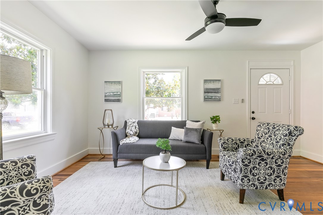 Living area featuring wood-finish flooring, white walls, and bright windows