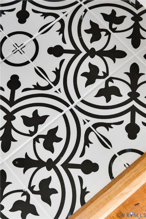 Black and white patterned tile flooring with contrasting wood-finish flooring