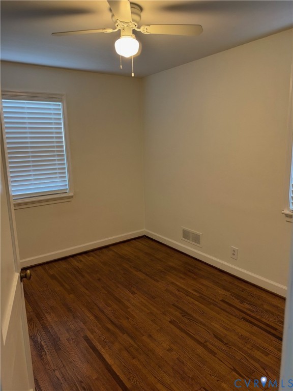 Room featuring wood-finish flooring, white walls, and a ceiling fan with integrated lighting, completed by windows with horizontal blinds