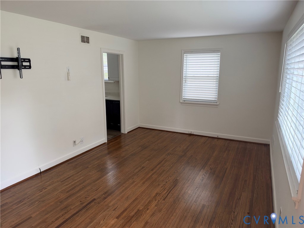 Wood-finish flooring, neutral wall tones, and horizontal window blinds