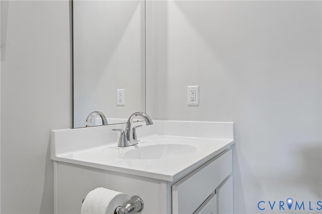 Single-basin vanity with a white countertop, chrome faucet, and integrated mirror