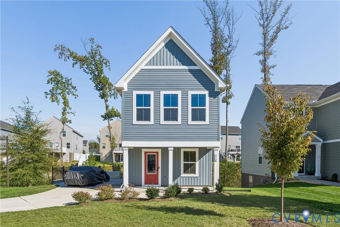 Two-story residence featuring horizontal and vertical lap siding, a covered front porch with square columns, and a front entry door with a glass pane