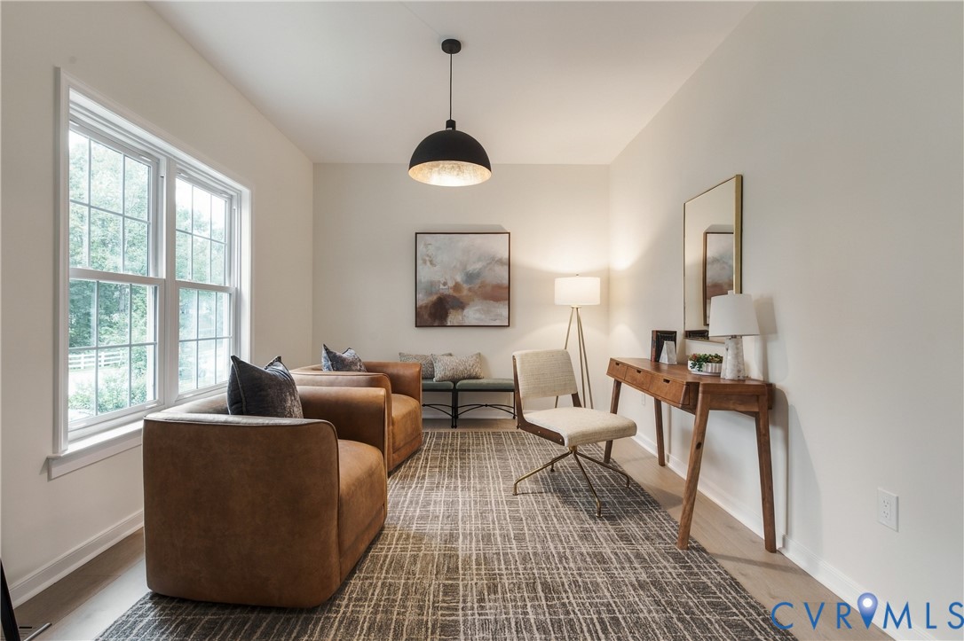 Neutral-toned room featuring a multi-pane window, wood-finish flooring, and a large black dome pendant light fixture Neutral-toned room featuring a multi-pane window, wood-finish flooring, and a large black dome pendant light fixture
