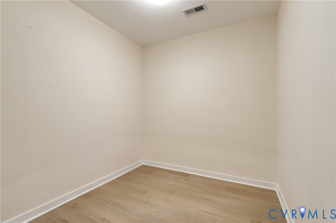 Neutral interior featuring wood-finish flooring and ceiling-mounted lighting
