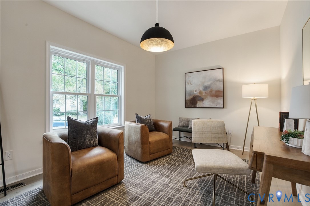 Neutral-toned room featuring a matte black pendant light with metallic gold interior finish and double-pane window Neutral-toned room featuring a matte black pendant light with metallic gold interior finish and double-pane window