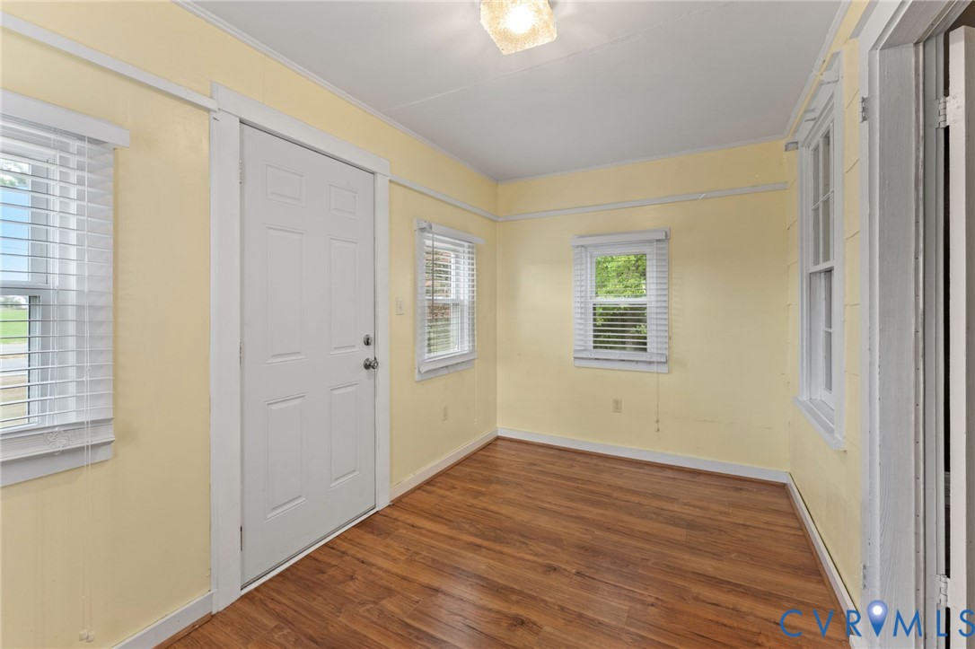 Enclosed front porch with pine floors.