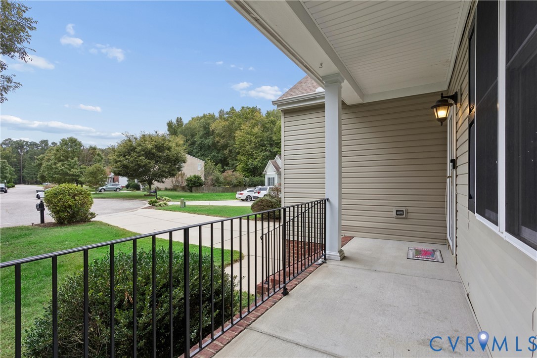 Covered front porch featuring a concrete floor, horizontal vinyl siding, a metal railing, and an attached wall-mounted lantern fixture