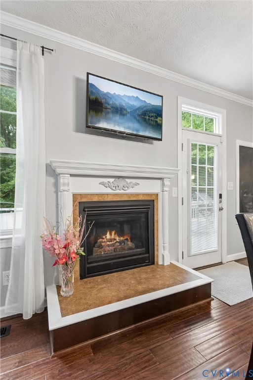 Fireplace featuring a white decorative mantel, tile surround, raised hearth, and wood-finish flooring