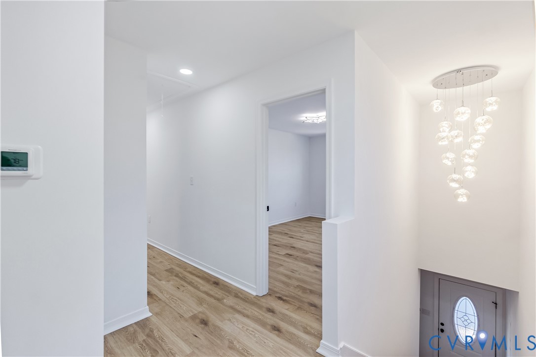 Interior area featuring wood-finish flooring, recessed lighting, and a multi-pendant glass chandelier