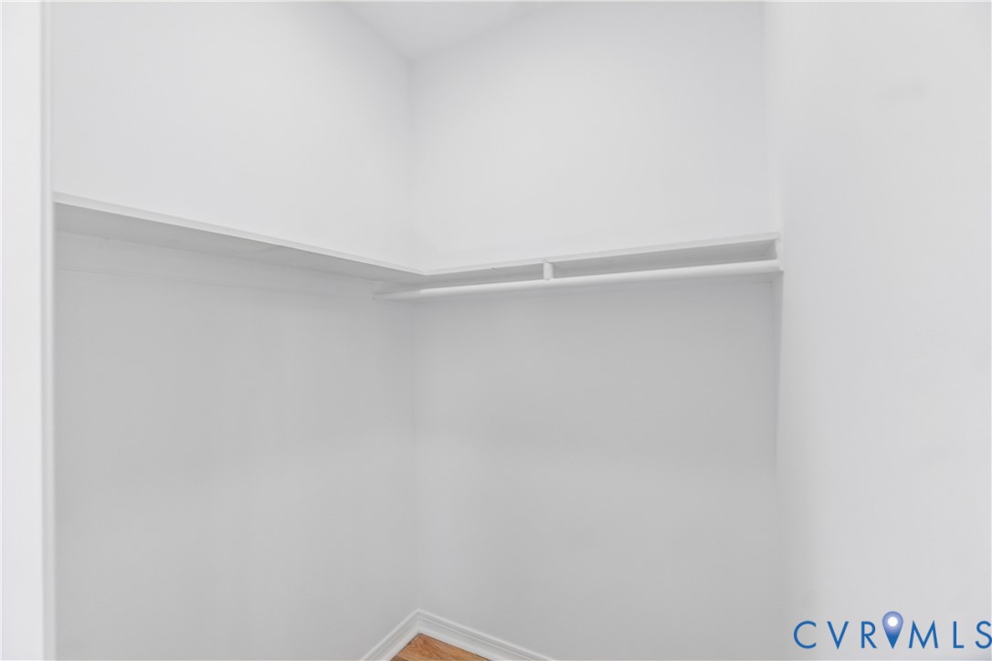 Built-in shelving and integrated hanging rod with wood-finish flooring