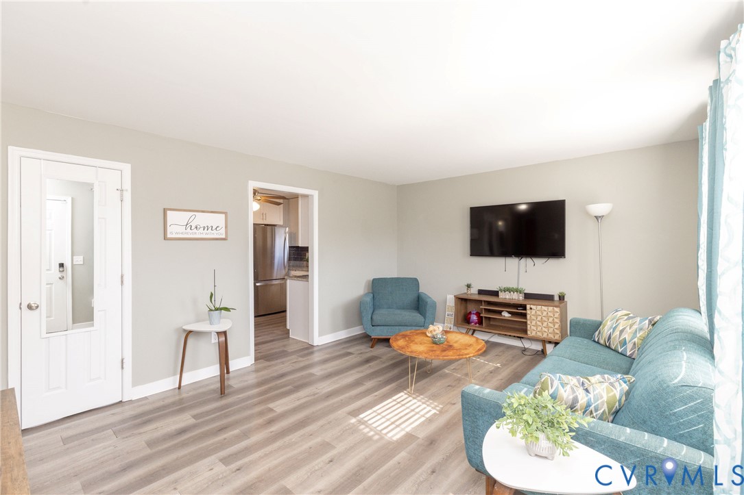 Living area featuring neutral wall paint, wood-finish flooring, and a glass-paneled interior door