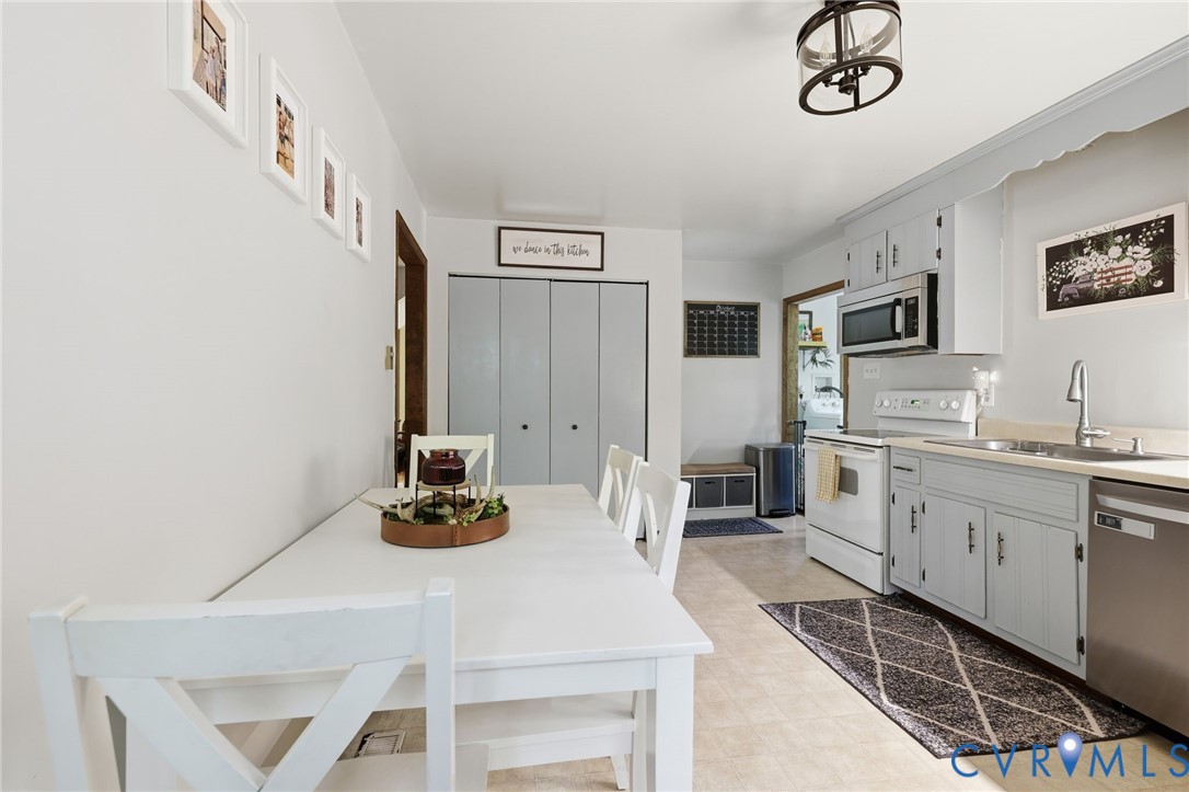 Kitchen featuring light blue cabinetry, pantry, stainless steel dishwasher, over-the-range microwave, and neutral-toned flooring