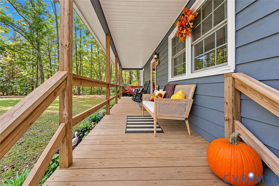Covered front porch featuring a horizontal lap siding exterior, wood railings, and multi-pane windows