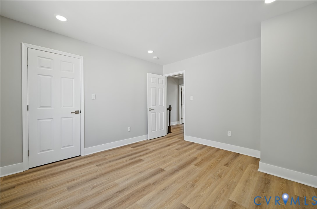 Neutral interior space featuring wood-finish flooring, recessed lighting, and multi-panel doors