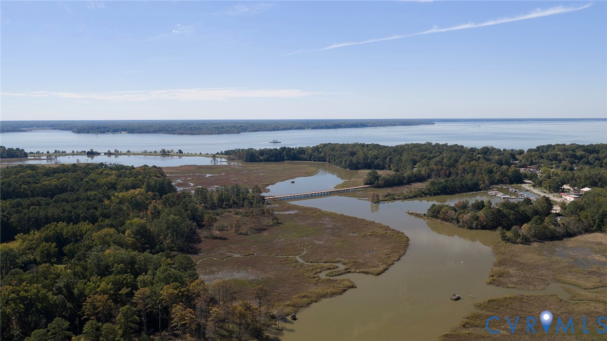Aerial perspective featuring expansive tidal marshland, wooded acreage, and coastal waterfront access