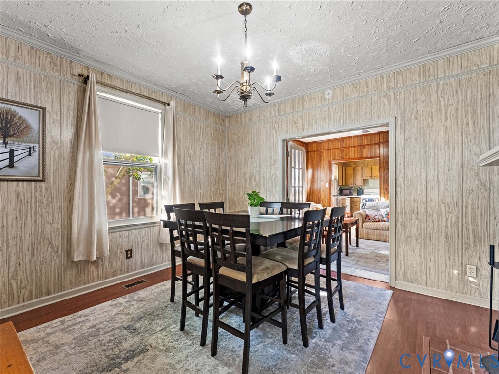 Wood-paneling wall finishes, multi-light chandelier, and wood-finish flooring