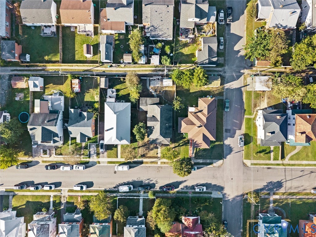 Aerial perspective of neighborhood featuring paved streets, established tree canopy, diverse roof lines, and defined property lots