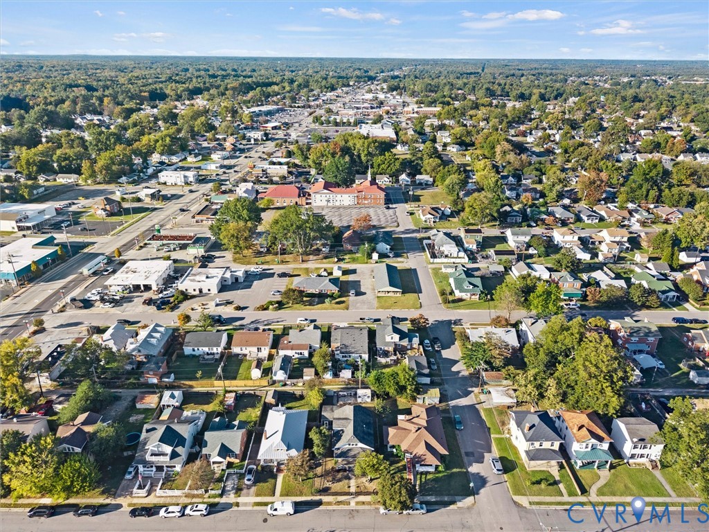 Aerial perspective of neighborhood and surrounding areas featuring mature tree canopy, paved street grids, and proximity to local commercial centers