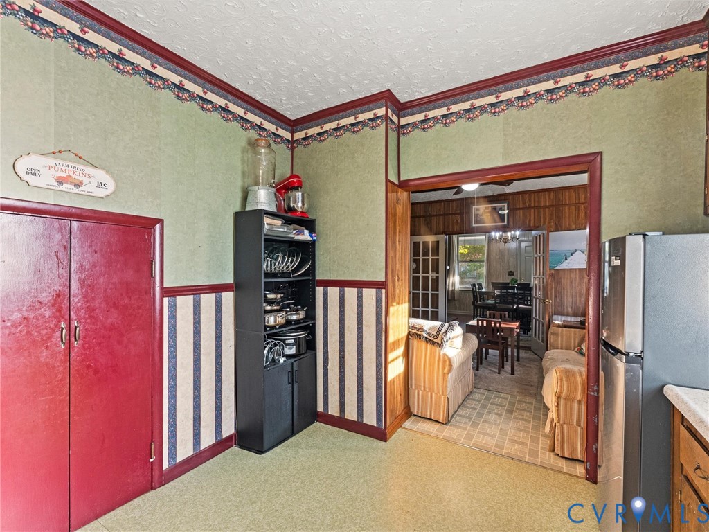 Kitchen featuring decorative crown trim and a stainless steel refrigerator