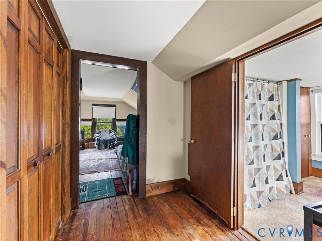 Interior hallway featuring stained wood flooring, closet, and stained wood trim work