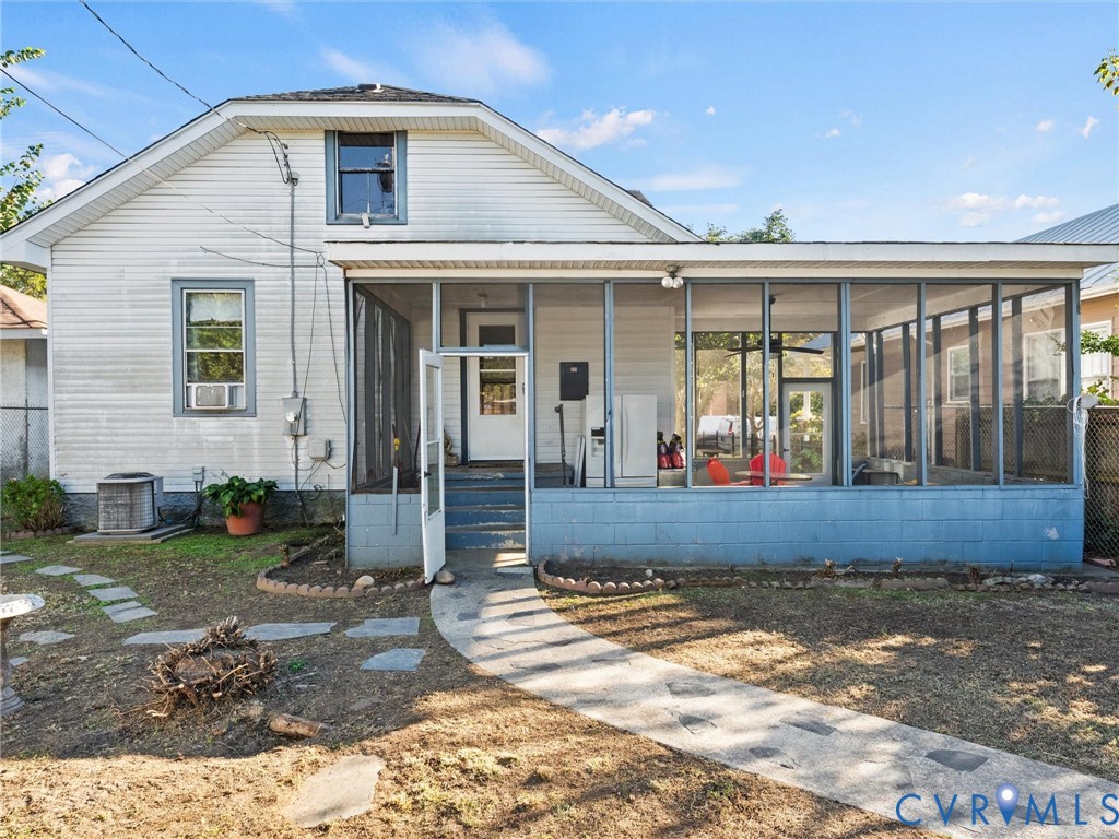 Exterior featuring an enclosed screened-in porch with a blue block foundation, concrete walkway, and step-up entry