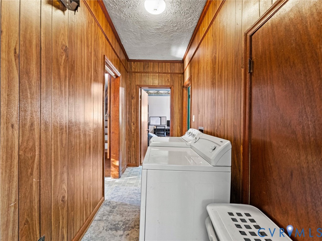 Hallway featuring wood-finish wall paneling, textured ceiling, and vinyl flooring