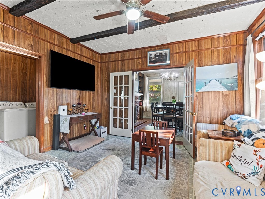 Wood-paneled walls, exposed ceiling beams, and white-framed French doors