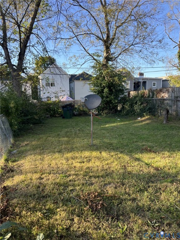Backyard featuring a grass lawn, perimeter fencing, and mature trees Backyard featuring a grass lawn, perimeter fencing, and mature trees