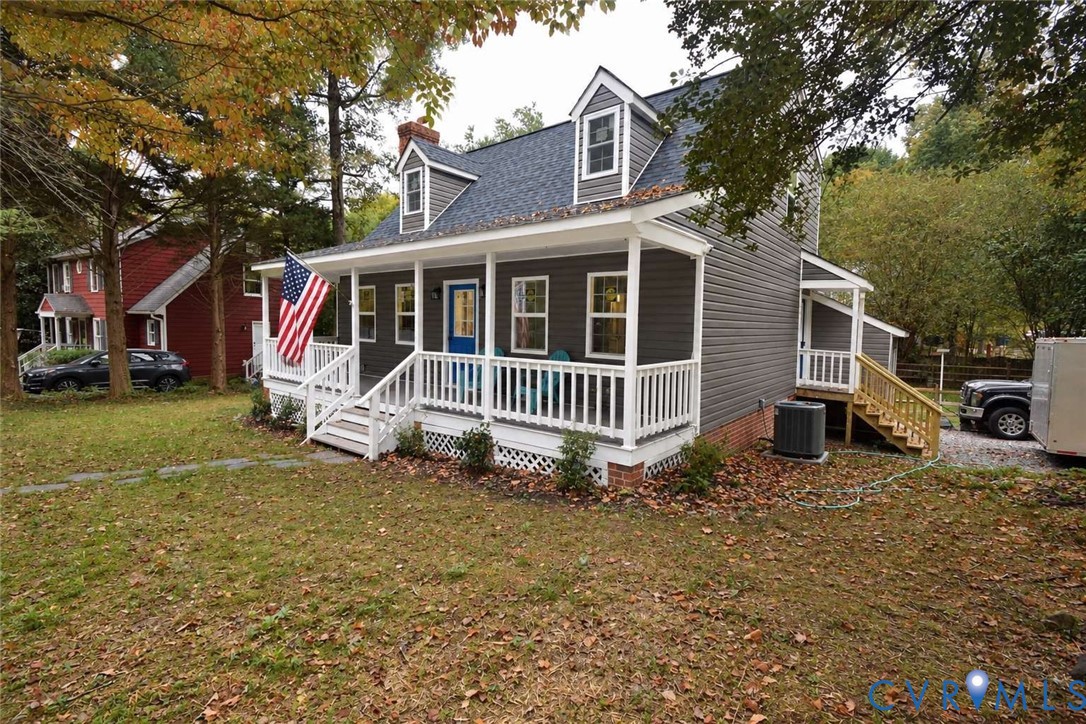 Cape Cod-style residence featuring horizontal lap siding, a front covered porch with white railings, and dual dormer windows