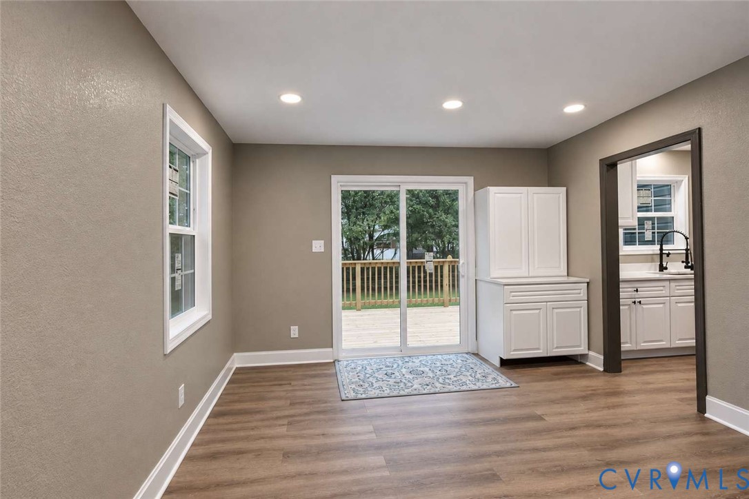 Wood-finish flooring, recessed lighting, sliding glass door, and built-in white cabinetry