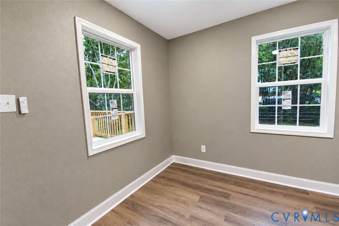 Neutral-toned wall paint, wood-finish flooring, and dual double-hung windows with grid detailing