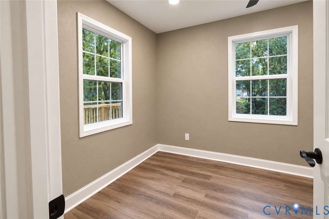 Neutral wall tones, wood-finish flooring, recessed lighting, and double-pane windows with grid detailing
