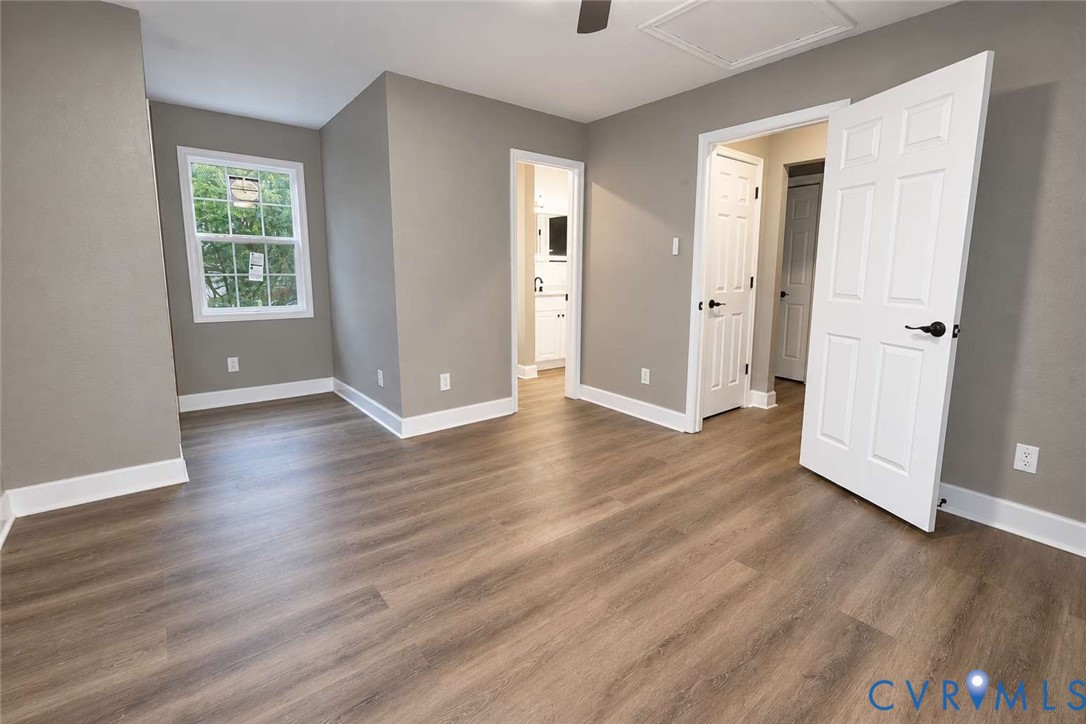 Neutral-toned interior space featuring wood-finish flooring, six-panel interior doors, and a single-hung window