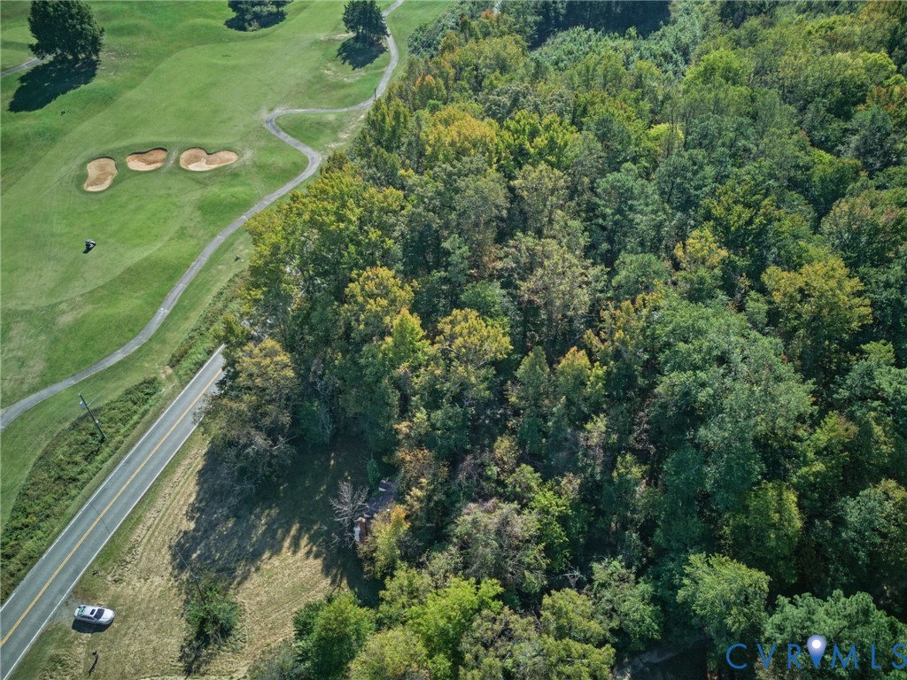 Aerial perspective of wooded parcel featuring dense mature timber and asphalt road frontage
